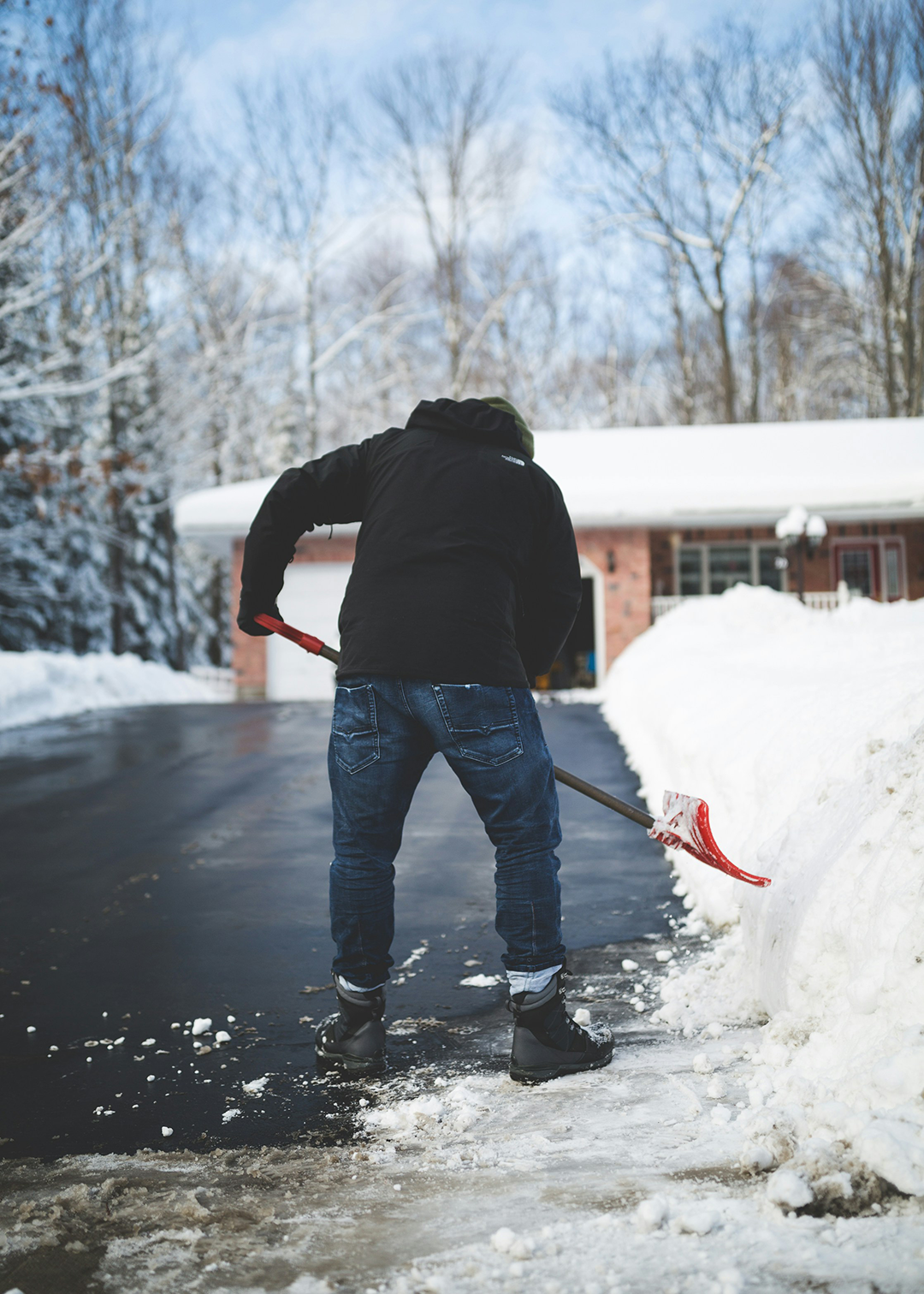 snow-clearing a person clearing snow on the driveway